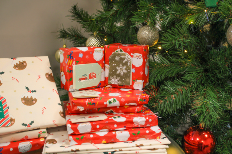 YMCA Christmas Book Donations. Christmas presents in front of a tree.