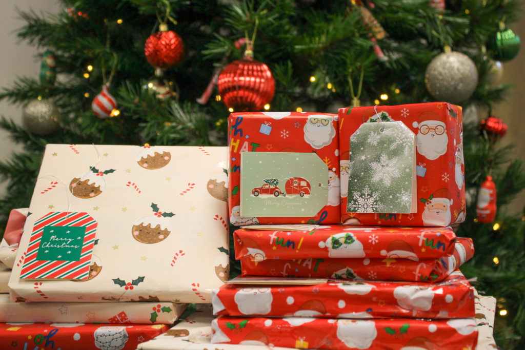 YMCA Christmas Book Donations. Christmas presents in front of a tree.